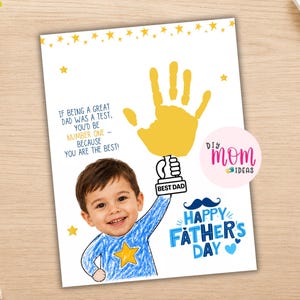 May include: A Father's Day card with a child's drawing and handprint. The card has the text "Happy Father's Day" and "Best Dad." The child's drawing includes a blue shirt with a yellow star. The card is handmade.