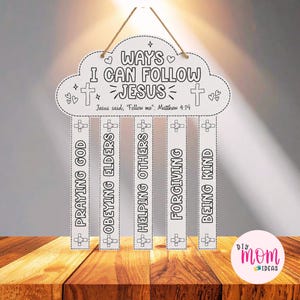 以下が含まれることがあります： 黒い輪郭と「WAYS I CAN FOLLOW JESUS, Jesus said, Follow me: Matthew 4:19」というテキストが書かれた白い雲の形の吊り下げ看板。5本の縦長の帯には「PRAYING GOD」「OBEYING ELDERS」「HELPING OTHERS」「FORGIVING」「BEING KIND」と記されている。