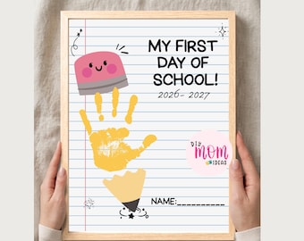 May include: A framed print on lined paper featuring the text MY FIRST DAY OF SCHOOL! 2026- 2027. The design includes a pink eraser graphic, a yellow handprint in the center, and a pencil tip graphic at the bottom with a blank line for a name.