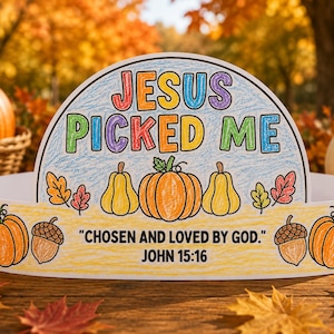 May include: A semi-circular paper crown featuring the text JESUS PICKED ME in multicolored crayon, with illustrations of pumpkins, gourds, and acorns. The base includes the text CHOSEN AND LOVED BY GOD. JOHN 15:16 printed in black ink.