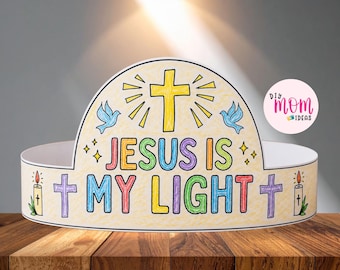 May include: A paper crown featuring the text JESUS IS MY LIGHT in multicolored letters. The design includes a yellow cross, two blue doves, two purple crosses, and two lit candles. The background is colored in light yellow with small star accents.