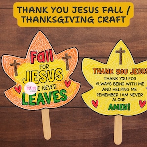 Puede incluir: Dos manualidades de papel en forma de hoja sobre palitos de madera. La hoja naranja tiene el texto Fall FOR JESUS HE NEVER LEAVES con dos cruces y dos corazones rojos. La hoja amarilla tiene el texto THANK YOU JESUS THANK YOU FOR ALWAYS BEING WITH ME AND HELPING ME REMEMBER I AM NEVER ALONE. AMEN! con una cruz y dos corazones rojos.