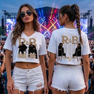 May include: A white cropped t-shirt featuring a graphic print of two figures in chairs with the text R&B TOUR, USHER, and CHRIS. The back of the shirt displays the same graphic with a list of tour dates. The design includes gold glitter accents.