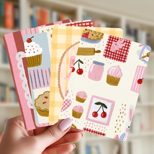 Peut inclure: Un ensemble de cartes rectangulaires illustrées de cupcakes, cerises, tartes et bocaux sur des fonds crème, jaunes et roses. Les motifs incluent des carreaux, des bordures en dentelle et de petits lapins dans un style illustratif doux et coloré.