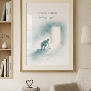Può includere: Stampa artistica incorniciata con una morbida illustrazione in stile acquerello. L'immagine raffigura una persona che striscia verso una porta luminosa, con il testo "it takes courage to begin again". Un piccolo cuore è sotto.