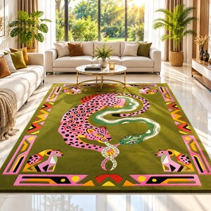 Puede incluir: Una alfombra rectangular que presenta un gran leopardo rosa con manchas negras y una serpiente verde entrelazadas en el centro. La alfombra tiene un fondo verde oliva y un borde decorativo con formas geométricas en rosa, naranja, amarillo y negro.