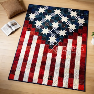 May include: A handcrafted quilt featuring the American flag design. The quilt showcases a blue field with white stars, red and white stripes, and a navy blue border. The quilt is made of various fabric patterns.