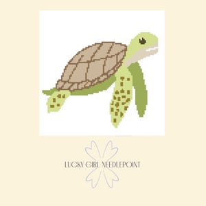 Puede incluir: Un diseño pixelado de tortuga marina en tonos verdes y marrones, sobre un fondo blanco. La tortuga tiene un caparazón y aletas detalladas. El texto "LUCKY GIRL NEEDLEPOINT" está debajo, acompañado de un diseño floral.