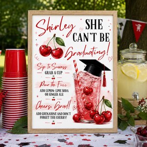 Puede incluir: Un letrero rectangular con marco de madera que presenta el texto Shirley SHE CAN'T BE Graduating! con ilustraciones de cerezas, un birrete de graduación e instrucciones para una estación de bebidas como Sip to Success, Pour the Fizz y Cheers, Grad!