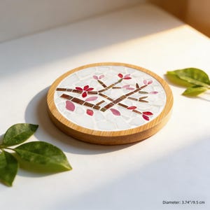 May include: Round wooden coaster with a mosaic design featuring a flowering branch with red and pink blossoms. The coaster has a diameter of 3.74 inches (9.5 cm).
