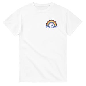 May include: White t-shirt featuring a rainbow design with the text "Gay Lynn" in a script font. The rainbow includes colors such as red, orange, yellow, green, blue, and purple. The shirt is made of a soft material.
