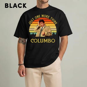 May include: Black t-shirt featuring a graphic of a man in a tan coat with the text "JUST ONE MORE THING" and "COLUMBO" in yellow. The design includes a sunset and trees. The word "BLACK" is printed at the top.