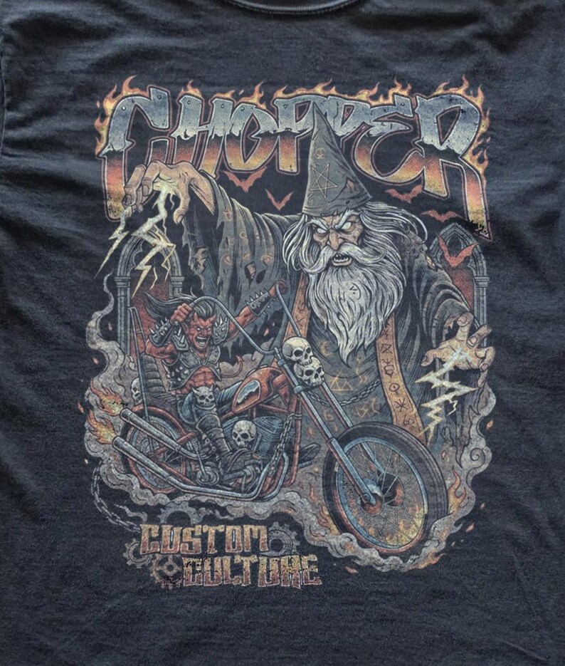 Close-up of a dark graphic tee design with a detailed wizard biker artwork, lightning effects, skulls, and bold “Chopper” typography in a fiery vintage metal-inspired style.
