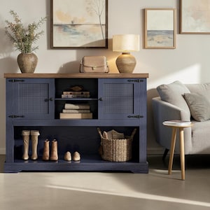 May include: A navy blue wooden console table with a natural wood top, featuring two cabinets with cane-textured doors, a central open shelf with books, and a lower open shelf containing two pairs of boots, a pair of shoes, and a woven basket.