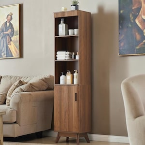 May include: A tall, wooden storage cabinet with a warm brown finish. The cabinet features open shelving and a lower section with a door. It is filled with toiletries, towels, and decorative items. The cabinet is set against a neutral wall.