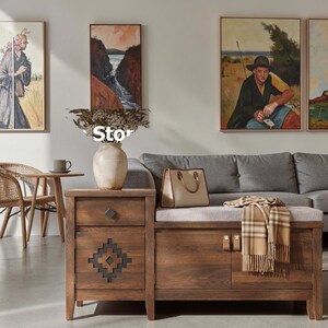 May include: A wooden storage bench with a single drawer and a cabinet door featuring a geometric cutout pattern. The bench has a light gray upholstered seat, a beige handbag, and a tan plaid scarf. A ceramic vase sits on the left side.