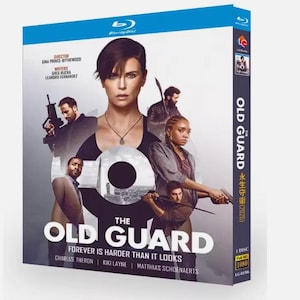 May include: Blu-ray disc case for the film "The Old Guard". The cover shows a cast of actors, including Charlize Theron, with the movie title in large white letters. The Blu-ray case is blue and black.