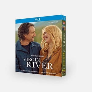 May include: A Blu-ray box set for the Netflix series "Virgin River" Season 7. The cover is blue and features a photo of two people smiling. The title "Virgin River" is displayed, along with the actors' names.
