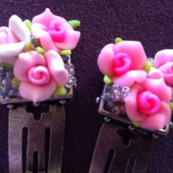 Two pink rosette hair clips.