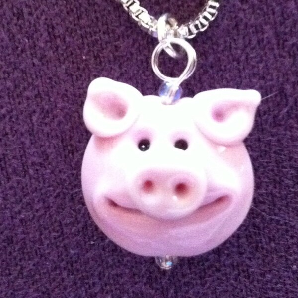 Cute, smiley lampwork glass piggy on a silver chain.