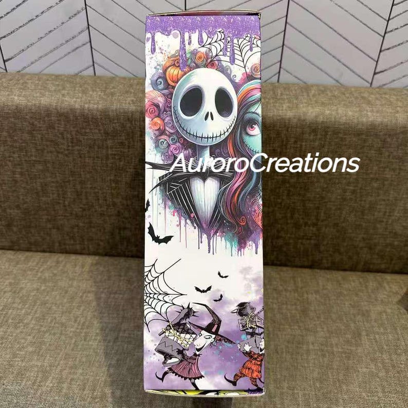 May include: A rectangular box featuring artwork from The Nightmare Before Christmas. The box has a purple top with dripping paint and a central image of Jack Skellington and Sally. The box also features bats, spiderwebs, and other characters from the movie.