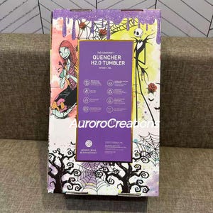 May include: A Stanley Flowstate Quencher H2.0 tumbler box featuring Sally and Jack Skellington from The Nightmare Before Christmas. The box has a purple and yellow background with roses, cobwebs, and trees. The tumbler holds 40 oz (1.18L).