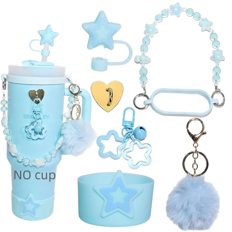 Pu&ograve; includere: Un bicchiere azzurro con accessori, tra cui un coperchio a forma di stella, un cinturino di perline e un portachiavi soffice. Il bicchiere ha un design a stella e il testo "NO cup". Sono inclusi accessori aggiuntivi.