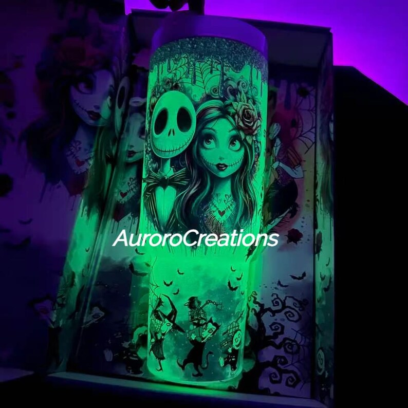 May include: A glowing green tumbler featuring Jack Skellington and Sally from The Nightmare Before Christmas. The tumbler has a glittery top and a wraparound design with the text "AuroroCreations". The design includes bats and other spooky elements.