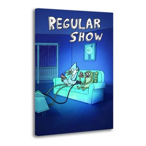 Op de afbeelding: Een rechthoekige canvasprint met het Regular Show logo bovenaan. Een blauwe vogel en een wasbeer zitten op een lichtblauwe bank, eten stukjes pizza en spelen een videogame met controllers die verbonden zijn met een televisie in een donkere kamer.