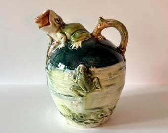 Antieke majolica-kan met figuratieve kikker en waterlelie