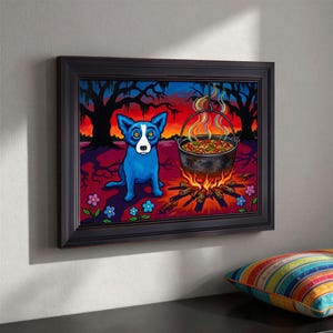 May include: Framed artwork featuring a blue dog with yellow eyes sitting near a campfire with a pot of food. The background shows a sunset and trees. The artwork is framed in a dark brown frame.