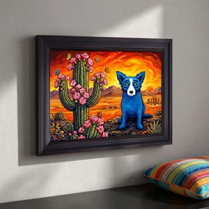 May include: Framed art print featuring a blue dog in a desert landscape with a cactus and butterflies. The artwork has a vibrant color palette of orange, pink, and blue, with a black frame. The dog is the focal point, sitting in front of a sunset.