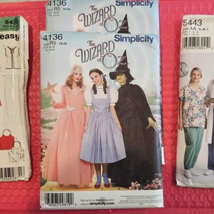 May include: Four sewing patterns for clothing. The patterns are for a jacket, a dress, a doctor's uniform, and a witch costume. The patterns are from the brands New Look and Simplicity.