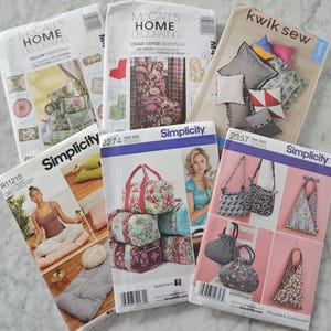 May include: A collection of sewing patterns for home decor and accessories. The patterns include instructions for making pillows, chair covers, bags, and other items. The patterns are from Simplicity and McCall's.