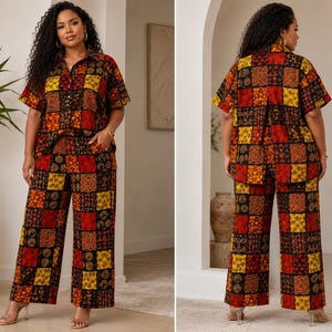 May include: A two-piece set consisting of a short-sleeved button-down shirt and wide-leg trousers. The garments feature a patchwork pattern with alternating squares in shades of red, yellow, orange, and black, displaying various geometric motifs.