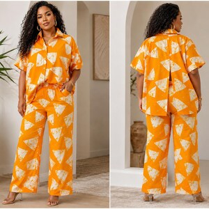 May include: A two-piece set consisting of a short-sleeved button-down shirt with a collar and wide-leg trousers. Both pieces feature a vibrant orange base color with a repeating white triangular pattern. The shirt has a split back design.