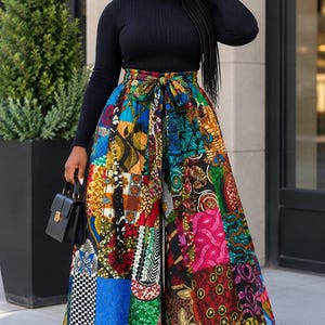 May include: A black long-sleeve turtleneck sweater paired with high-waisted, wide-leg trousers featuring a vibrant, multi-colored patchwork pattern of various geometric and floral prints, complete with a matching fabric tie belt at the waist.