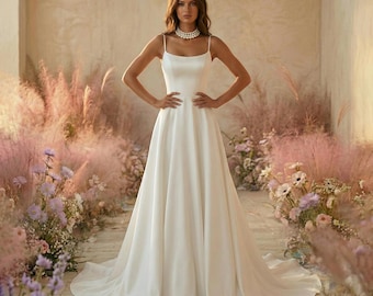 Vestido de novia de satén mate con corte en A, escote cuadrado, tirantes finos y bolsillos.