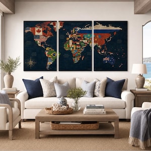 May include: A three-panel wall art set featuring a world map with a dark blue background. Each country is filled with its respective national flag. The map includes a compass rose in the bottom left corner and is displayed above a sofa.
