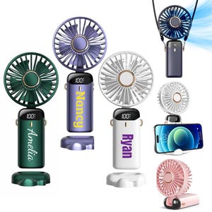 Op de afbeelding: Een verzameling draagbare persoonlijke ventilatoren in verschillende kleuren, waaronder groen, paars, wit, blauw en roze. Elke ventilator heeft een digitaal display en een naam op de handgreep. Sommige ventilatoren worden getoond met een oplaadkabel en een smartphone.