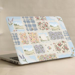 Può includere: Una skin per laptop con un design a patchwork, bordi azzurri e finiture in pizzo bianco smerlato. Il motivo include quadrati a quadri blu, stampe floreali con rose e fiori di campo, e scene paesaggistiche con dolci colline verdi.