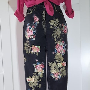 Könnte beinhalten: Ein magentafarbenes, langärmeliges Hemd mit Knopfleiste, das in der Taille geknotet ist, kombiniert mit einer schwarzen Jeans mit einem Blumenmuster aus rosa, roten und grünen Rosen sowie kleinen, in den Stoff integrierten rechteckigen Aufnähern.