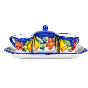 May include: A ceramic tea set featuring a rectangular tray, a lidded sugar bowl, and two cups. The pieces are white with hand-painted blue rims and a vibrant pattern of yellow lemons, green leaves, and red flowers against a white background.