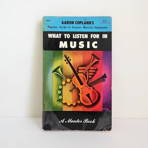 May include: A Mentor Book paperback titled "What to Listen For in Music" by Aaron Copland. The cover features a colorful illustration of musical instruments, including a violin, trumpet, and flute.