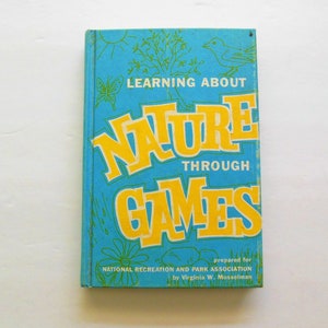 May include: A blue book with the title "Learning About Nature Through Games" in yellow letters. The book is prepared for the National Recreation and Park Association by Virginia W. Musselman.
