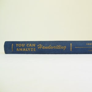 May include: A blue book with gold lettering that reads "You Can Analyze Handwriting".