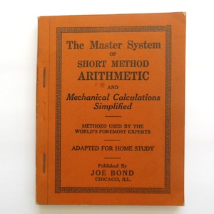 May include: An orange book titled "The Master System of Short Method Arithmetic and Mechanical Calculations Simplified." The cover features black text and a decorative border. Published by Joe Bond, Chicago, ILL.