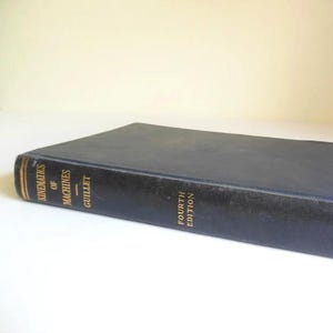 May include: A black leather-bound book titled "Kinematics of Machines" by Gullet, Fourth Edition.