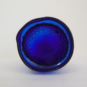 May include: The bottom of a cobalt blue glass pitcher with a textured surface.