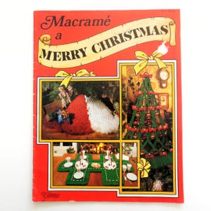 May include: A vintage book cover with the title "Macramé a MERRY CHRISTMAS" in a banner across the top. The cover is red with images of macramé Christmas decorations, including a Santa hat, tree, and table setting.